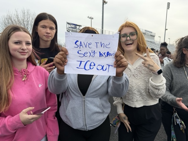 A norview student holding a sign reading 'SAVE THE SEXY HISPANICS. ICE OUT'